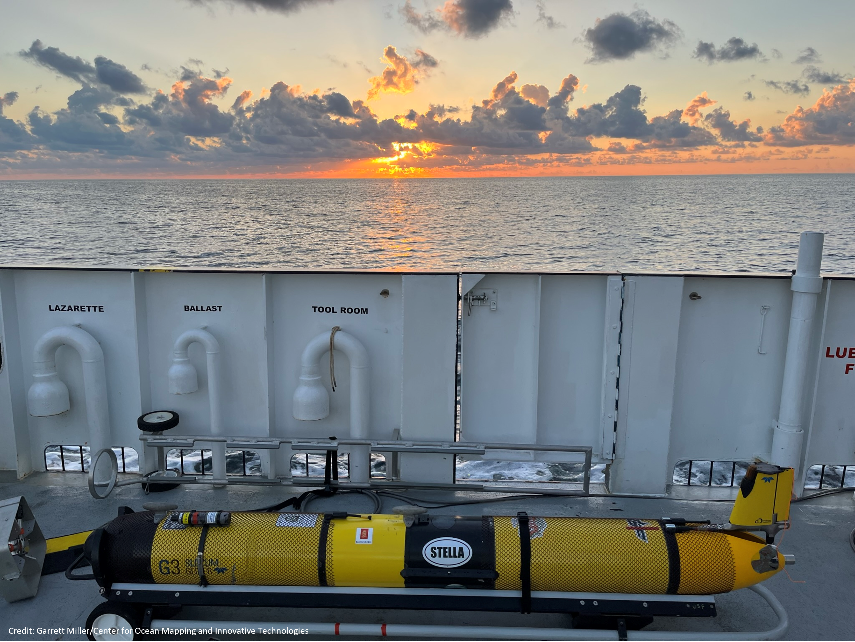 oceanic glider on deck of ship with sunset in the background.