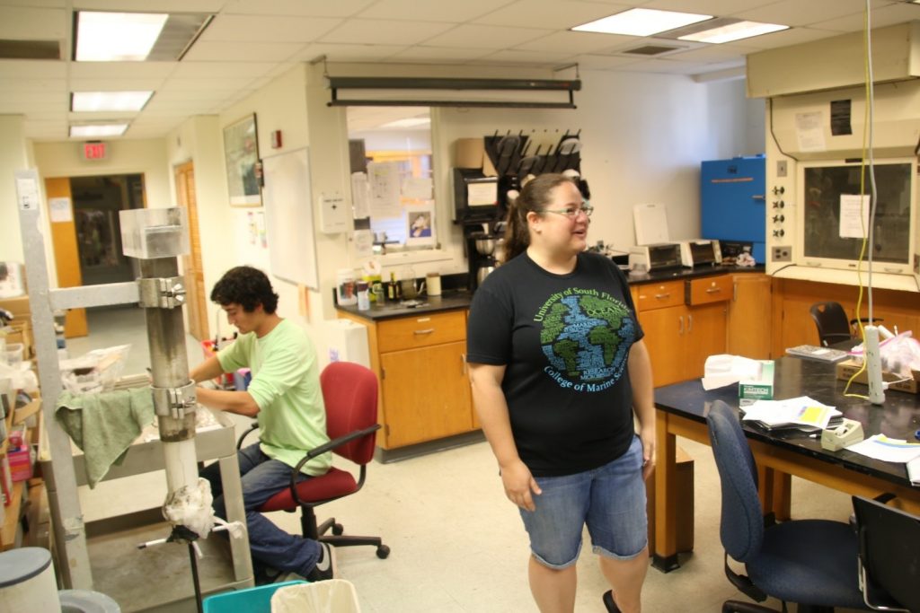 Mya Breitbart, microbiological oceanographer, directs the attention of the REU group to Eckerd College student Duke Thornburgh (shown seated), who is preparing sections of a sediment core for analysis
