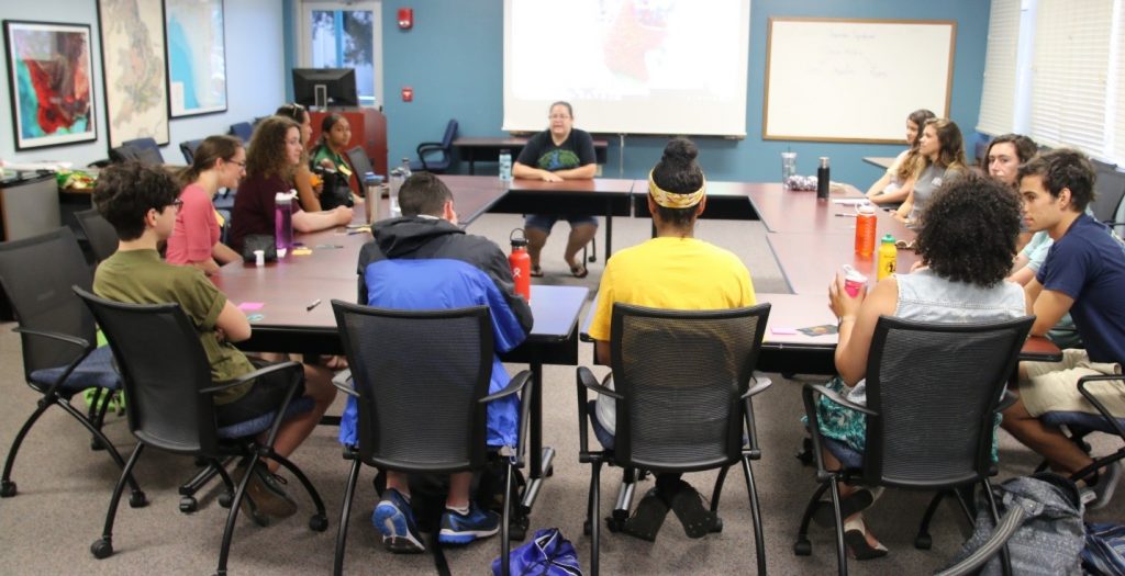 Mya Breitbart (seated, top center) conducts a round-table style seminar on the art of using social media as an outlet for scientific research