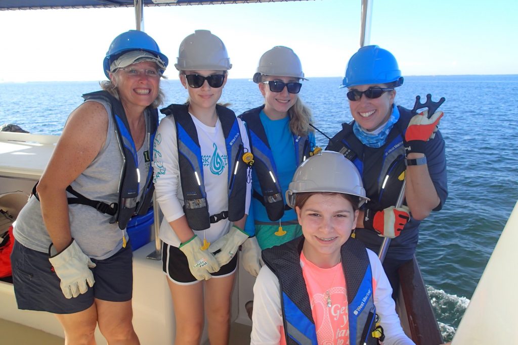 Camp director, Dr. Teresa Greely, posing with campers and an R/V ANGARI staff member before conducting a plankton net tow. Photo credit: OCG Staff