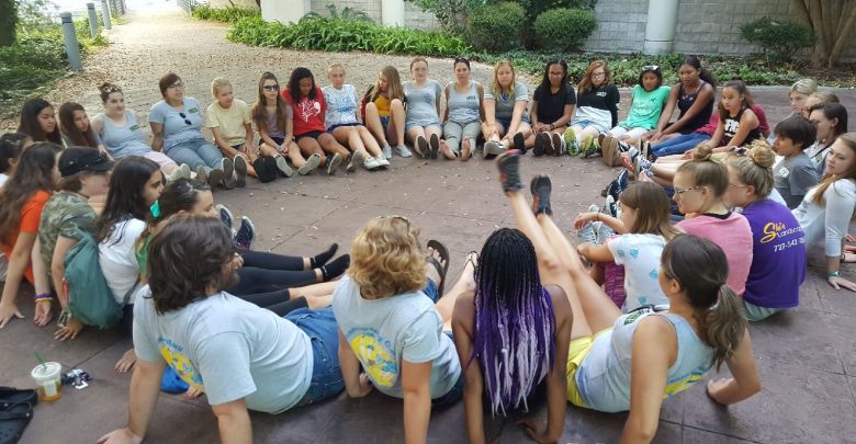 OCG campers and mentors sit in a circle to discuss science
