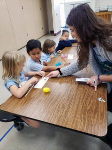 Makenzie Kerr helping the students decipher their DNA beads into DNA code. Makenzie Kerr helping the students decipher their DNA beads into DNA code.
