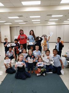 Tricia Burrows (Makenzie's aunt) and Makenzie Kerr with a first grade class. They are holding up the fish coloring pages they got by deciphering which fish their egg was from. Tricia Burrows (Makenzie's aunt) and Makenzie Kerr with a first grade class. They are holding up the fish coloring pages they got by deciphering which fish their egg was from.